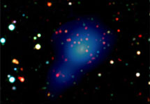 На этом цветном изображении видны слабые красные галактики скопления XMMXCS 2215-1738 (в центре) наряду с синеватым "облаком", которое на самом деле представляет собой наложение снимка в рентгеновском диапазоне (рентгеновские лучи невидимы для человеческого глаза), это излучение от чрезвычайно горячего газа, что окутывает все галактическое скопление (European Southern Observatory Imaging Survey; NOAO/photo)
