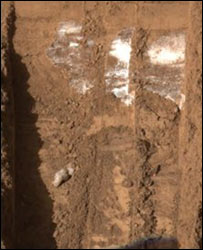 Полагают, что блестящие частицы в траншеях, прорытых марсианским аппаратом, - это лед. Фото с сайта BBC News