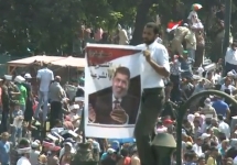 Демонстрант держит портрет Мохамеда Мурси. Кадр Би-Би-Си